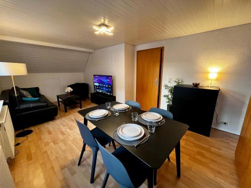 a living room with a table and chairs and a couch at OhPardon! GAILDORF - Monteurwohnung im DG, Einzelbetten, Garten in Gaildorf