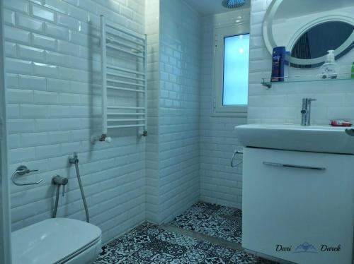 a white bathroom with a sink and a toilet at mezzanine in Hammamet