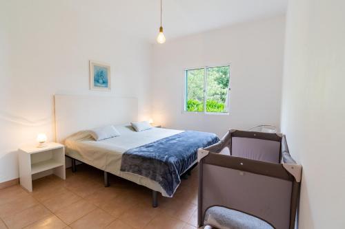 a bedroom with a bed and a window at Bungalows Do Amparo in Ponta do Pargo