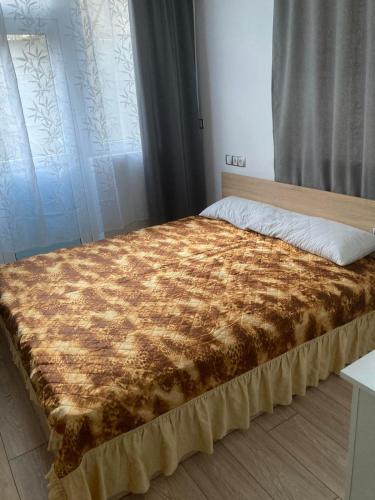 a bed with a brown blanket on top of it at Studio "Victoria" in Burgas City