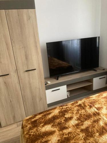 a living room with a flat screen tv on a entertainment center at Studio "Victoria" in Burgas City