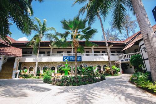 un edificio con palme di fronte ad esso di Jangwani Sea Breeze Resort a Dar es Salaam