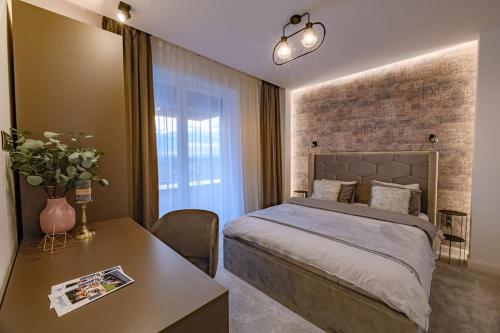 - une chambre avec un lit, une table et une fenêtre dans l'établissement BRAVISA Apart View, à Braşov