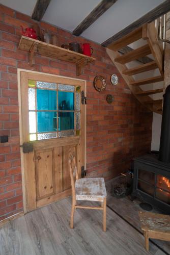 a room with a door and a chair and a stove at Mieciówka in Lasowka