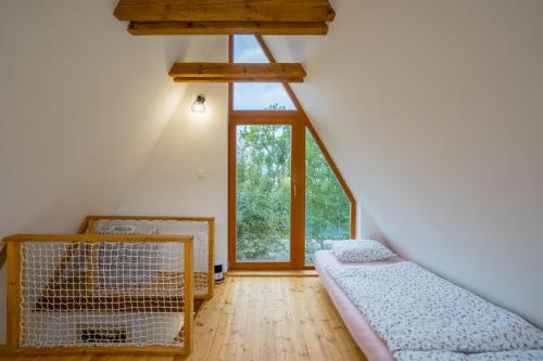 a attic room with two beds and a large window at AKORD chata in Námestovo