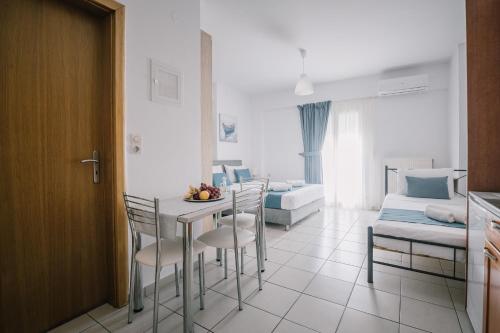 a living room with a table and chairs and a bed at Joy Apartment in Rethymno