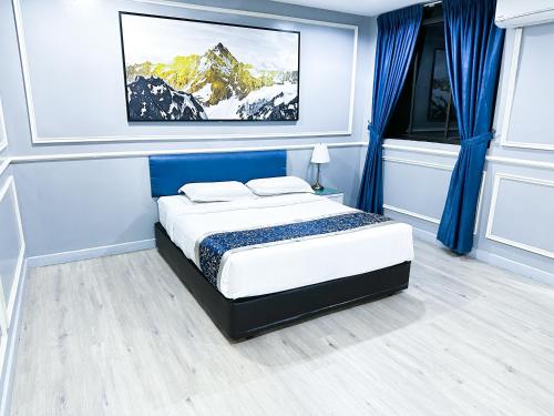 a bedroom with a bed and a painting on the wall at 61 Hotel in Gua Musang