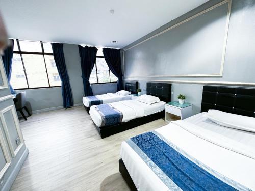 Habitación de hotel con 2 camas y 2 ventanas en 61 Hotel en Gua Musang