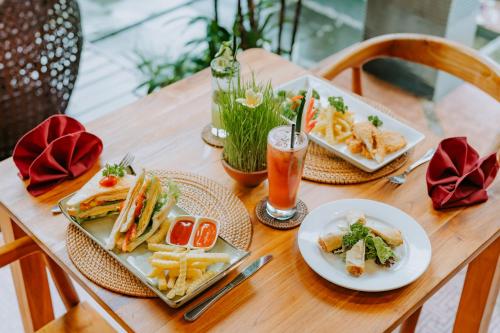a table with plates of food and a drink at Dewangga Ubud in Ubud
