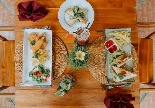 a table with three plates of food on it at Dewangga Ubud in Ubud
