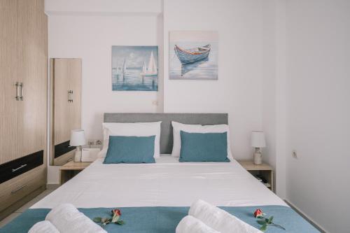 a bedroom with a large white bed with blue pillows at Joy Apartment in Rethymno