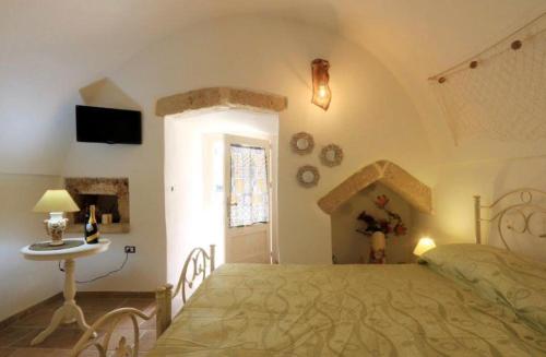 1 dormitorio con 1 cama grande y 1 mesa en Villa Telly, en Presicce