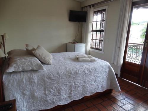 1 dormitorio con 1 cama con 2 toallas en Pousada Azaléia, en Rio das Flores