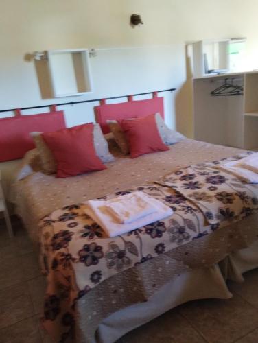 een slaapkamer met een bed met rode kussens bij Montalto in Dina Huapi
