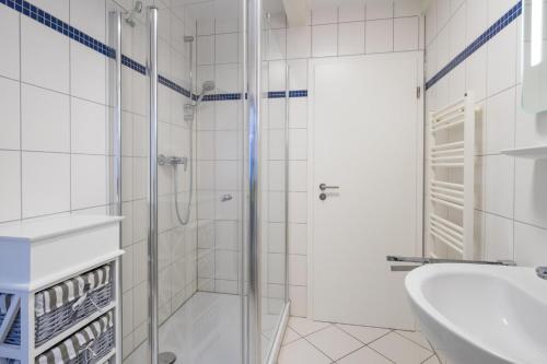 a white bathroom with a shower and a sink at Villa Bellevue 3 _App_ 12 in Ahlbeck