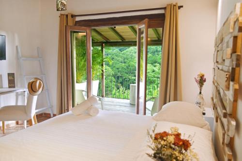 a bedroom with a bed and a sliding glass door at Sweet Harmony Hotel Boutique by Xarm Hotels in Minca
