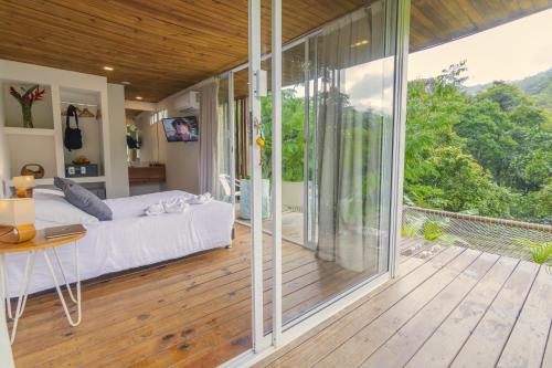a bedroom with a bed and a balcony with sliding glass doors at Sweet Harmony Hotel Boutique by Xarm Hotels in Minca