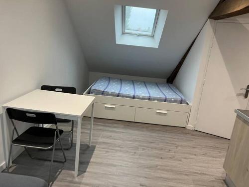 a small room with a bed and a table at 2 Appartement neuf centre ville proche gare et commerces in Flers