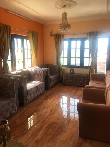 ein Wohnzimmer mit Sofas und Fenstern in der Unterkunft Apartment at Balkot, Nepal in Thimi