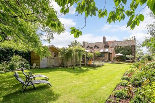 un banco de parque en el patio de una casa en Garden Lodge close to Wakehurst and Kew Seed Bank Ardingly, en Ardingly