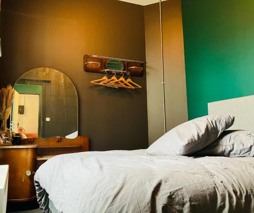 1 dormitorio con cama, espejo y lavamanos en BnB Suikernest, en Amberes