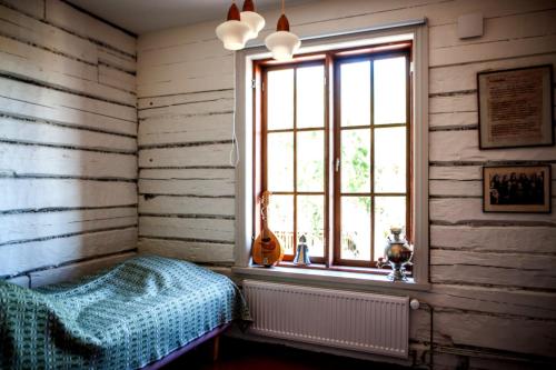 a bedroom with a bed and a window with a guitar at Matkustajakoti Ykspihlaja in Kokkola