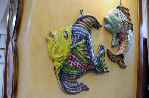 two fish ornaments are hanging on a wall at Hotel Ristorante Regina in Mozzanica