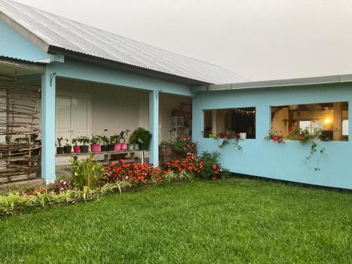 a house with flowers and plants in a yard at Au coeur de la Cascade Biberon in La Plaine des Palmistes