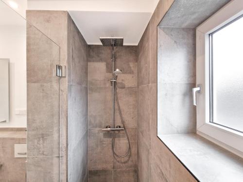 a shower with a glass door in a bathroom at RAJ Living - City Apartments with 1 or 2 Rooms - 15 Min to Messe DUS and Old Town DUS in Düsseldorf