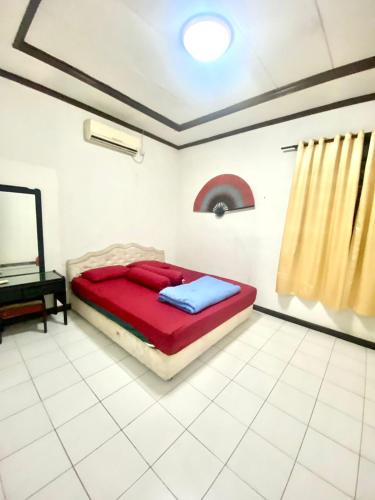 a bedroom with a bed with red and blue at Fania Villa in Cinengangirang