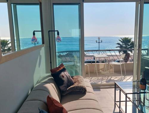 un canapé dans une pièce avec vue sur l'océan dans l'établissement Nice Promenade des Anglais Vue Mer, à Nice