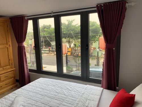 - une chambre avec un lit et une grande fenêtre dans l'établissement Bờ Sông Hotel, à Hô-Chi-Minh-Ville