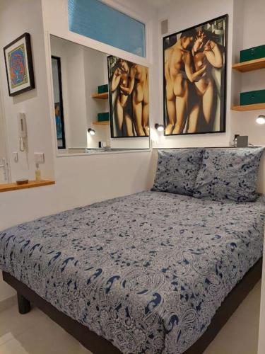 une chambre avec un lit avec deux tableaux au mur dans l'établissement Nice Promenade des Anglais Vue Mer, à Nice