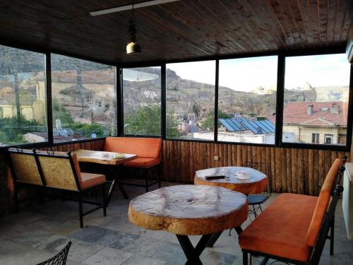 een restaurant met tafels en stoelen en grote ramen bij Sandık cave house in Nevsehir