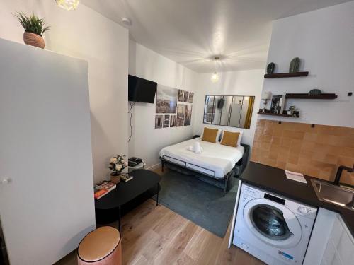 a small room with a washing machine and a bed at EXPOSITION APPARTEMENT in Paris