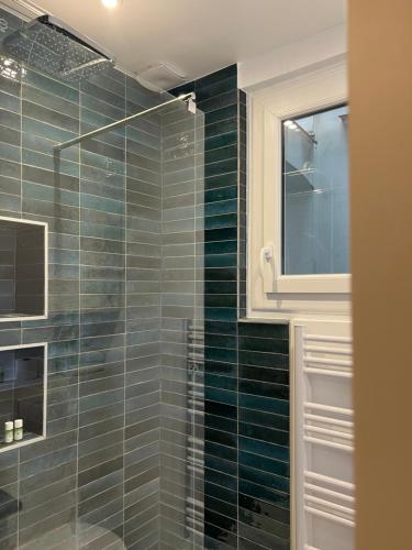 La salle de bains est pourvue d'une douche avec du carrelage vert. dans l'établissement Tour Eiffel Apartment, à Paris
