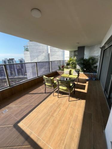 a balcony with a table and chairs on a building at luxury condo in Qiryat Motzkin