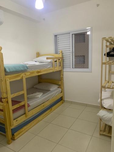 1 dormitorio con literas en una habitación con ventana en Apartamento Guarujá Lazer completo Villa Di Fiori 600mts da praia, en Guarujá