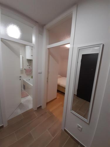 um corredor com um espelho num quarto em Apartman Lena em Banja Luka