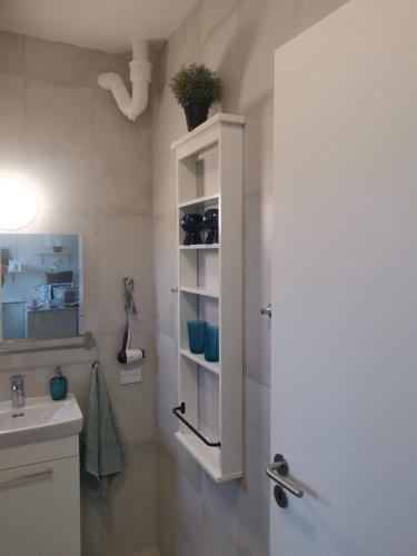a bathroom with a sink and a white cabinet at Copenhagen, Perfect apt. near the beach. in Copenhagen