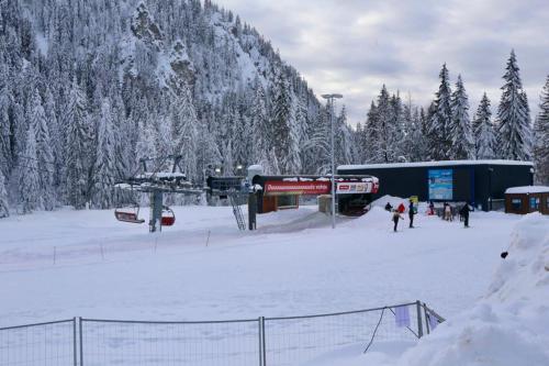 a group of people standing in the snow near a ski lift at Apartman Carra in Jahorina