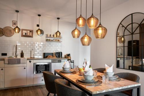 a kitchen with a table and chairs and pendant lights at Park Avenue - Design Apartment Friesenstraße - 4 Pers - WLAN - Netflix - 65 Zoll TV in Cologne