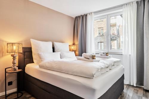 - une chambre avec un grand lit blanc et une fenêtre dans l'établissement Park Avenue - Design Apartment Friesenstraße - 4 Pers - WLAN - Netflix - 65 Zoll TV, à Cologne