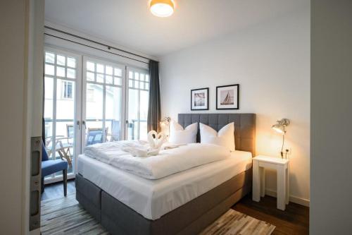una camera da letto con un grande letto bianco e una finestra di Villa Westend App_ 17 a Ahlbeck