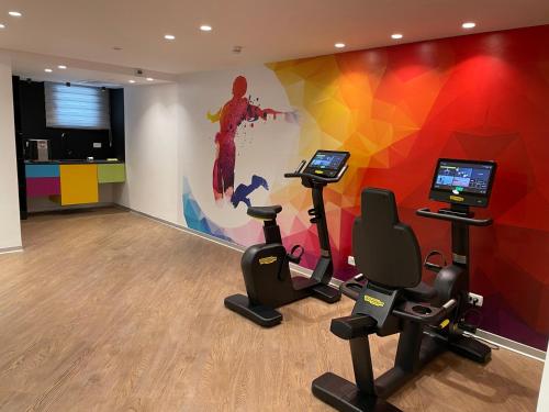 a gym with exercise bikes and a colorful wall at luxury condo in Qiryat Motzkin