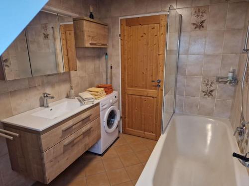 a bathroom with a sink and a washing machine at Ferienwohnung am Steinwald 