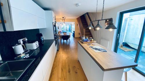 a kitchen with black and white counters and a table at Tregenna House - St Ives, A Beautiful Newly Refurbished 4 Bedroom Family Town House With Alfresco Dining Garden and Private Parking Spaces in St Ives