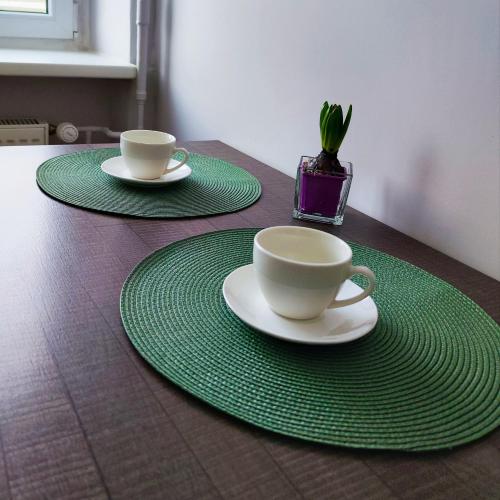 two coffee cups and saucers on a table at Station street apartments in Sigulda