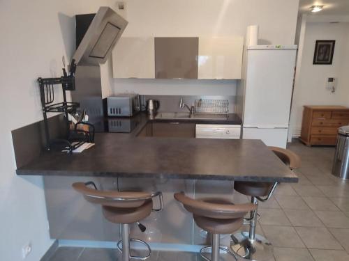 a kitchen with a counter and some bar stools at Appartement proche aéroport Orly in Athis-Mons