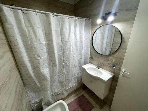 baño con cortina de ducha blanca y lavamanos en Hermoso departamento para 4 en la mejor zona de Núñez- Ibera en Buenos Aires